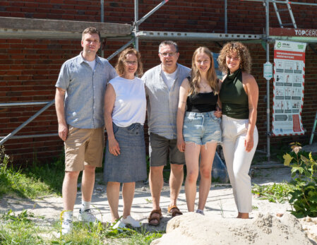 Lächelndes Hotelteam vor dem Haus