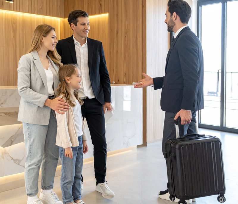 Gastgeberfamilie, die Gäste im Hotel begrüßt