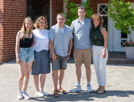 Lächelndes Hotelteam vor dem Haus