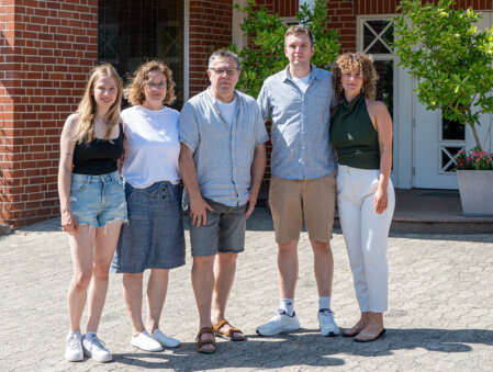 Lächelndes Hotelteam vor dem Haus